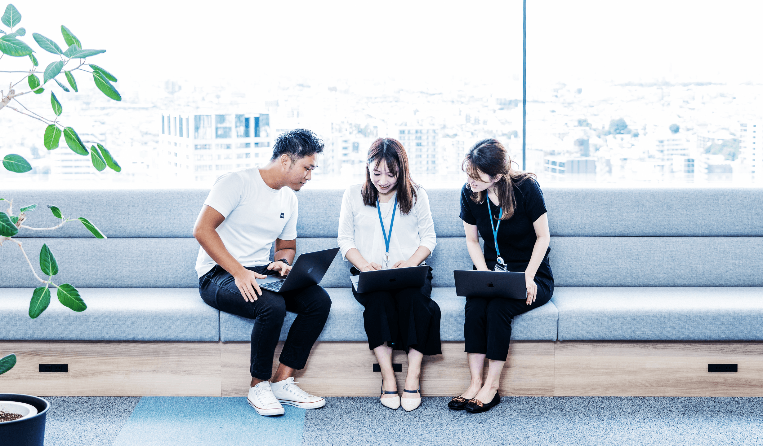 トヨクモ社員が座りながら１つのノートパソコンの画面を覗いている様子